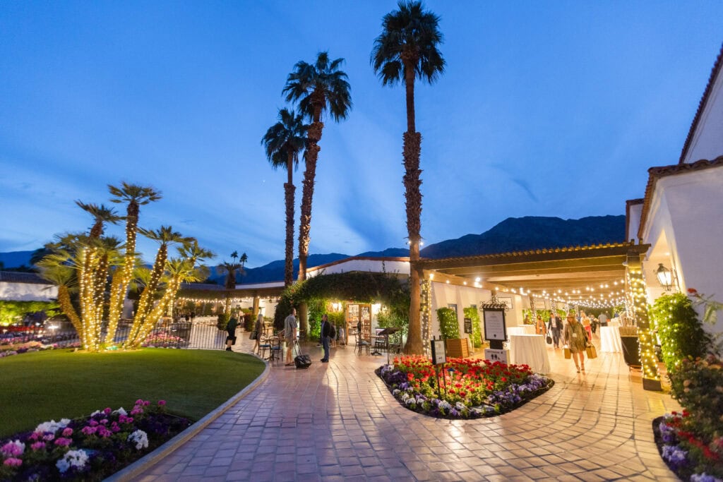 Hotel courtyard at dusk with lights and palm trees