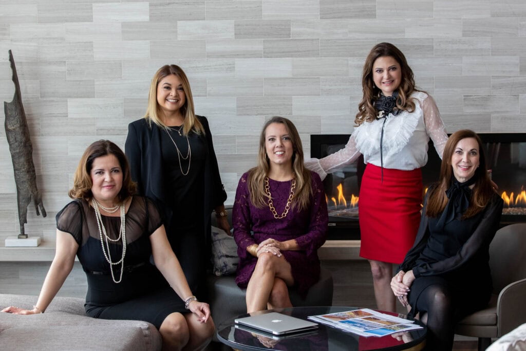 Women in a modern office dressed in business attire.