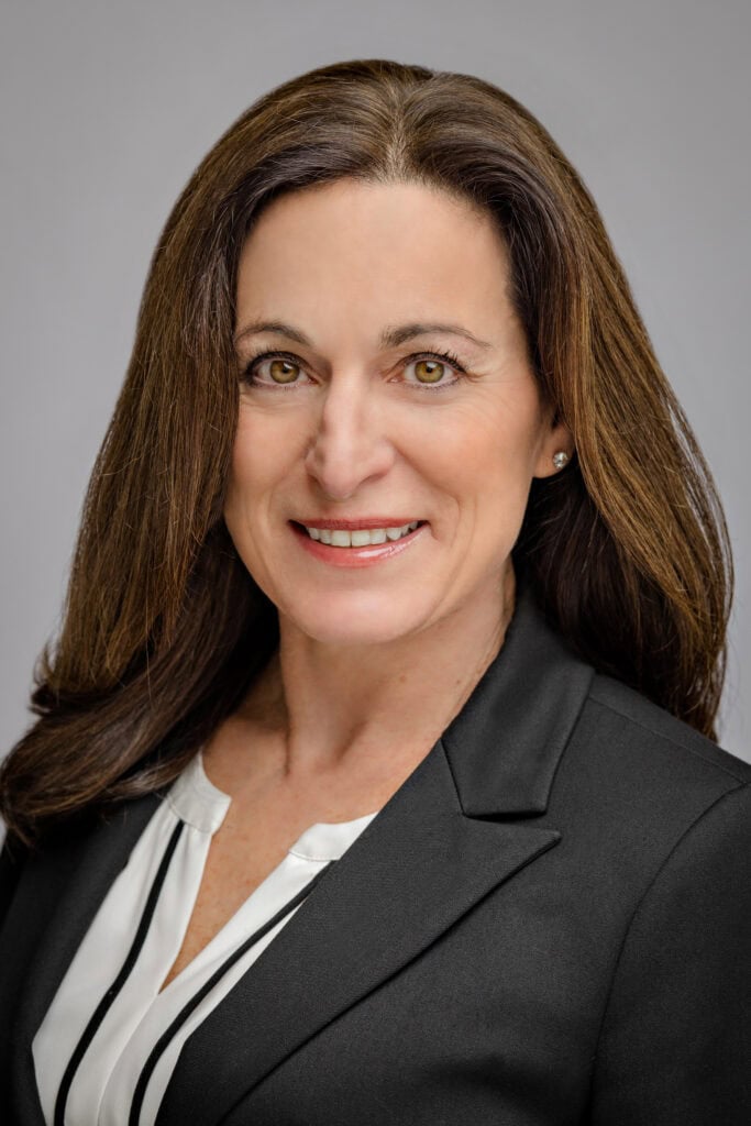Headshot of a woman in a dark grey blazer