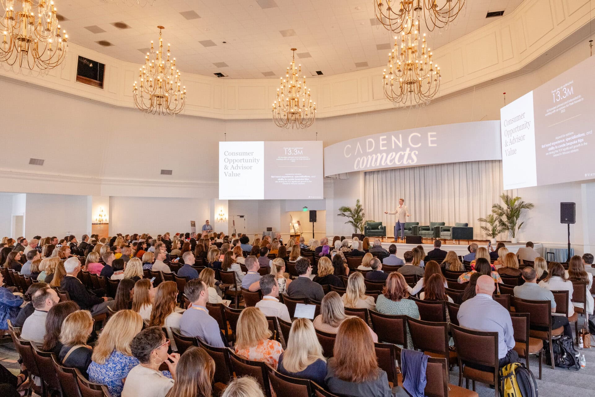 Seated audience in an auditorium watching a speaker present during a conference.
