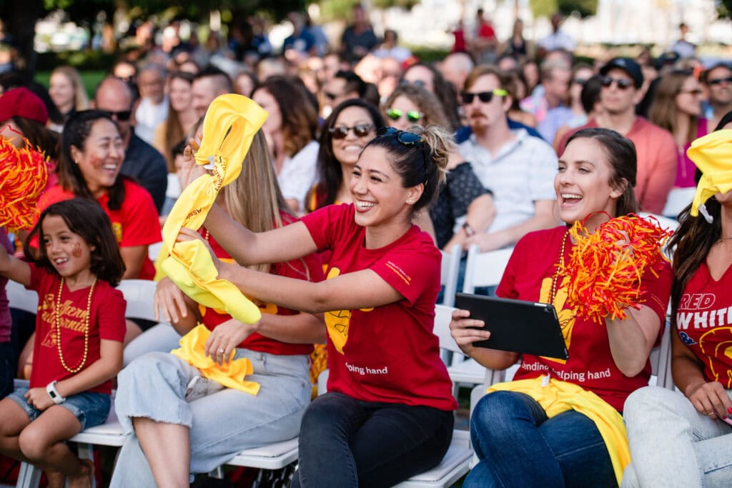 A crowd of people smiling during a business team building event