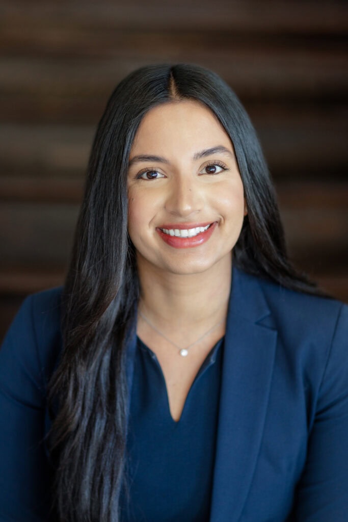 Headshot of a woman with dark hair and a dark blazer