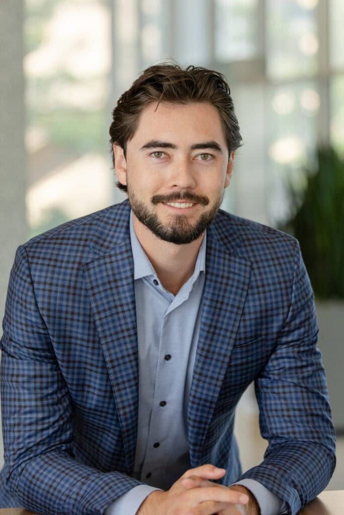 Headshot of a main in a subtle plaid blazer