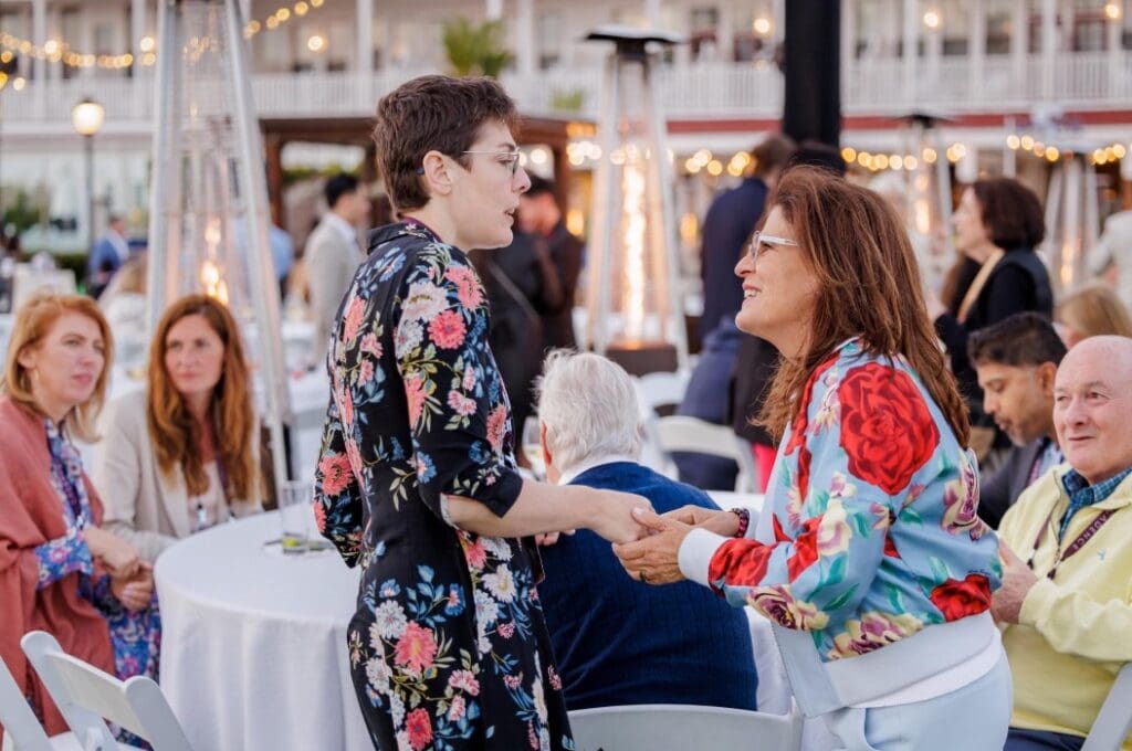 Two people exchange a greeting during a business event