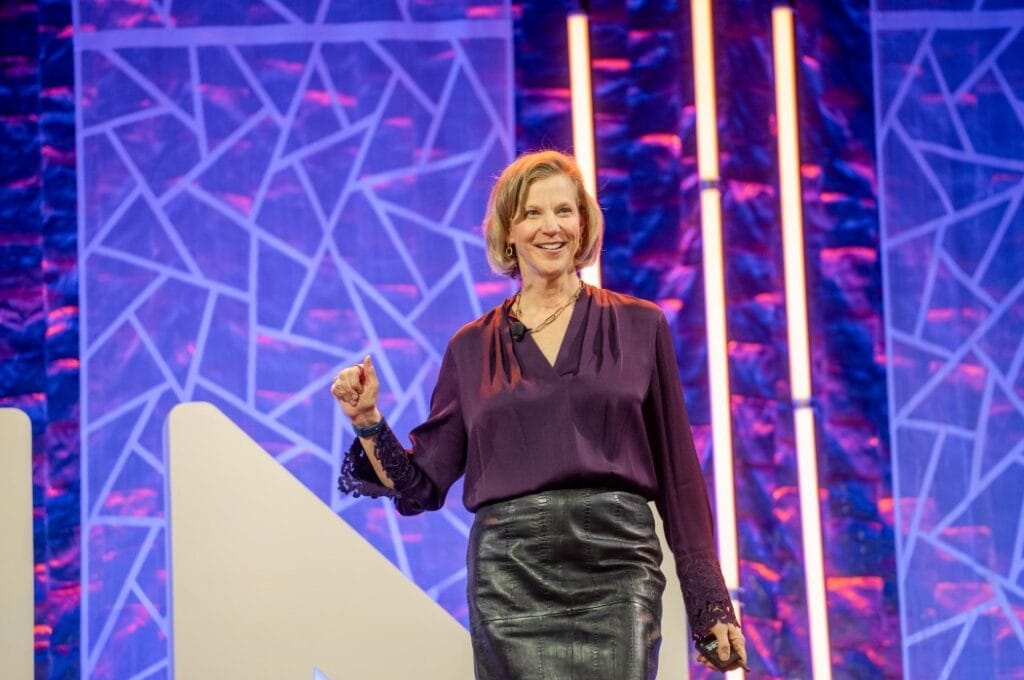A woman giving a presentation on stage during a business conference