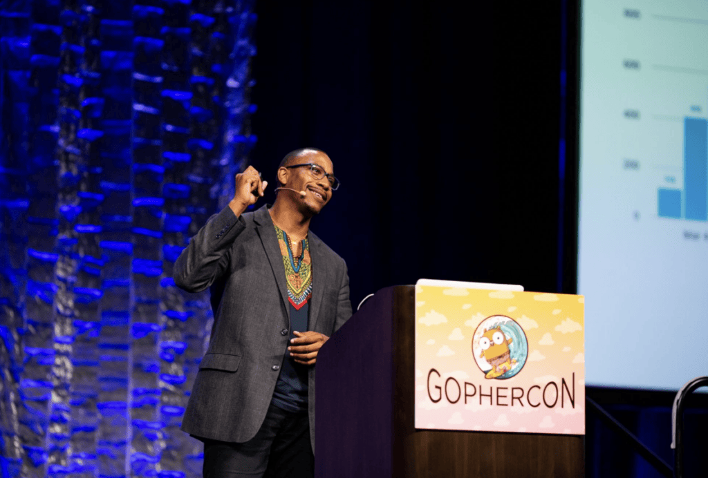 A man stands at a podium and pumps his fist.