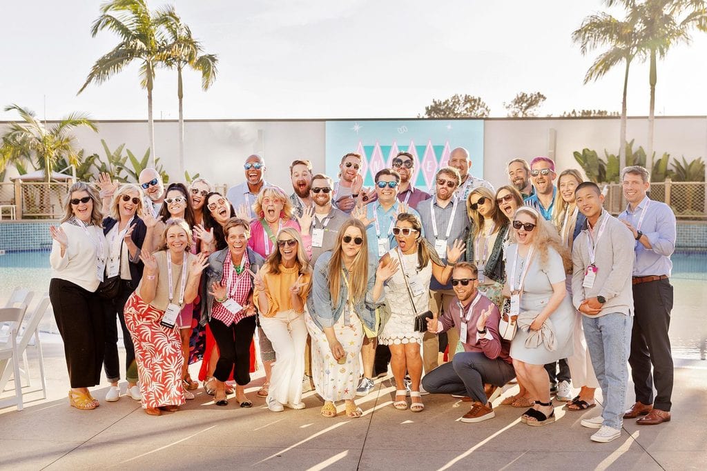Group of professionals posing together outdoors at a corporate event.