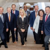 Small group of people in business attire posed in the stairway of a modern office building