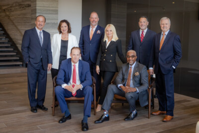 Group of people in business attire pose in a modern office