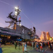 Group of people gathered for a party on the deck of a US Navy ship