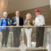 Group of people on a stairway landing holding cocktails in business attire