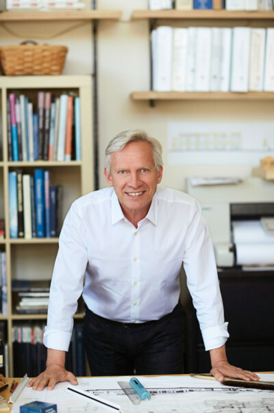 Portrait of a man in front of his work on a drafting table.