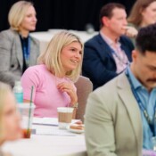 An audience member smiles during a presentation at a business event