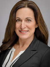 Headshot of a woman in a dark grey blazer