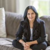 A woman sits cross-legged on a couch