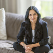 A woman sits cross-legged on a couch