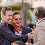 People embracing and smiling outdoors during a business event