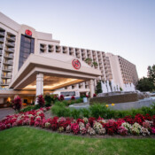 Hotel building with flowers and a water fountain in front
