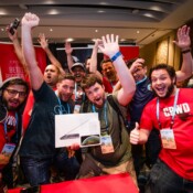 A boisterous group poses during a conference afterparty