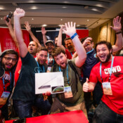 A boisterous group poses during a conference afterparty