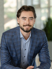 Headshot of a main in a subtle plaid blazer