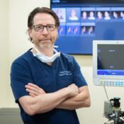 A man in a doctor's office modes next to medical equipment