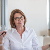 A woman in a candid pose, holding a glass of wine